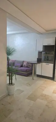 a kitchen with a table and a couch in a room at Appartement Flora Nora in Casablanca