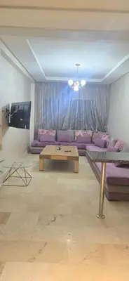 a living room with a purple couch and a table at Appartement Flora Nora in Casablanca