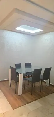 a dining room with a table and four chairs at Appartement Flora Nora in Casablanca