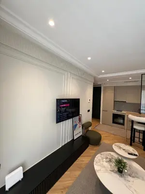 a living room with two tables and a kitchen at Appartement Le Claridge in Casablanca