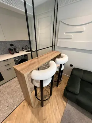 a kitchen with a wooden table and two stools at Appartement Le Claridge in Casablanca