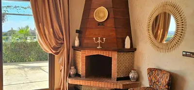 a living room with a fireplace and a mirror at Bougainvilla Guesthouse in Sidi Moussa Ben Ali