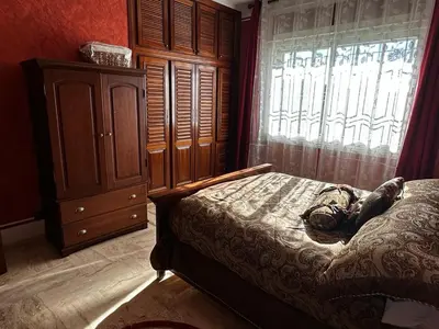a bedroom with a bed with a dresser and a window at Villa in mohammadia morrocco in Mohammedia