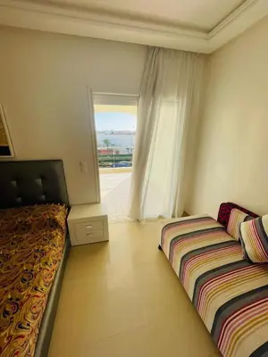 a bedroom with two beds and a window at Ola blanca 1 enjoy in Sidi Rahal