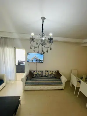 a living room with a couch and a chandelier at Ola blanca 1 enjoy in Sidi Rahal