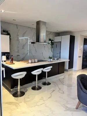 a kitchen with two bar stools and a counter at Appartament Melrose beach dar bouazza in Tamaris