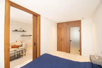 a bedroom with a door leading to a living room at Appartement Ferme Bretonne - Confort & Premium in Casablanca