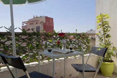 a table and two chairs on a balcony at R106- Amazing & Colourful Apartment near High Speed Train Station in Casablanca