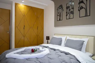 a bedroom with a white bed with a wooden door at R106- Amazing & Colourful Apartment near High Speed Train Station in Casablanca