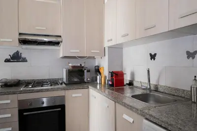 a kitchen with white cabinets and a sink and a microwave at R106- Amazing & Colourful Apartment near High Speed Train Station in Casablanca