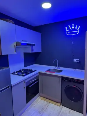 a blue kitchen with a sink and a dishwasher at Studio a maarif in Maarif