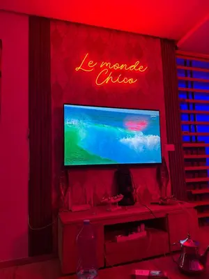 a television on a wall with a neon sign on it at Studio a maarif in Maarif