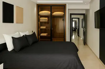 a bedroom with a large black bed and a hallway at Rooftop in Maarif