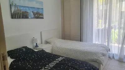 a bedroom with two beds and a window at Ground floor apartment - Residence Skhirat Beach 2 in Skhirat
