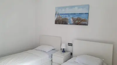a bedroom with two beds and a picture on the wall at Ground floor apartment - Residence Skhirat Beach 2 in Skhirat