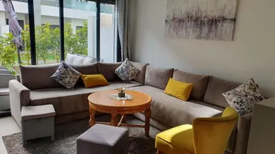 a living room with a couch and a table at Ground floor apartment - Residence Skhirat Beach 2 in Skhirat
