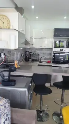 a kitchen with two bar stools and a counter top at Ground floor apartment - Residence Skhirat Beach 2 in Skhirat
