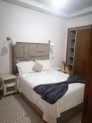 a bedroom with a large bed and a guitar at Apparemment haut standing Mansbay in Mohammedia