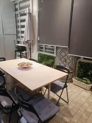 a table and chairs in a room with a window at Apparemment haut standing Mansbay in Mohammedia