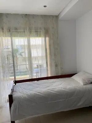 a bedroom with a bed and a large window at Cozy beach house in Skhirat