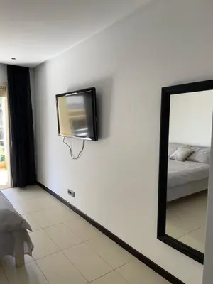 a flat screen tv on a wall with a mirror at Cozy beach house in Skhirat