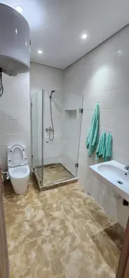 a bathroom with a shower and a toilet and a sink at Belle Appartent Vue Piscine A Malaga Beach A Mansouria in Mansouria