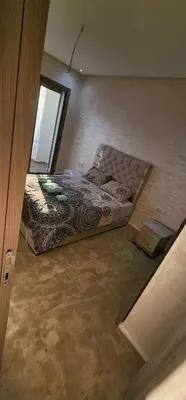 a bedroom with a bed in the corner of a room at Belle Appartent Vue Piscine A Malaga Beach A Mansouria in Mansouria