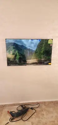 a flat screen tv hanging on a wall at Belle Appartent Vue Piscine A Malaga Beach A Mansouria in Mansouria