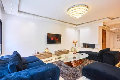 a living room with two blue couches and a table at Casablanca 3 Bed Unit in Triangle Dor With Parking in Casablanca