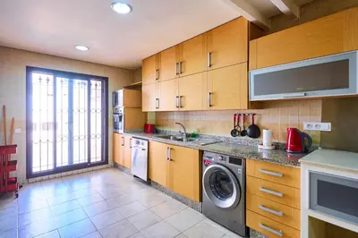 a kitchen with wooden cabinets and a washer and dryer at Casablanca 3 Bed Unit in Triangle Dor With Parking in Casablanca
