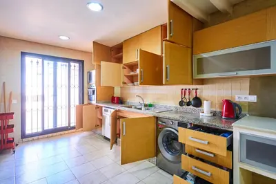 a kitchen with wooden cabinets and a washing machine at Casablanca 3 Bed Unit in Triangle Dor With Parking in Casablanca
