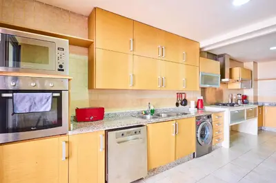a kitchen with wooden cabinets and stainless steel appliances at Casablanca 3 Bed Unit in Triangle Dor With Parking in Casablanca