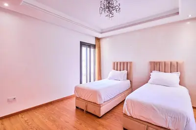 two beds in a room with white walls and wood floors at Casablanca 3 Bed Unit in Triangle Dor With Parking in Casablanca