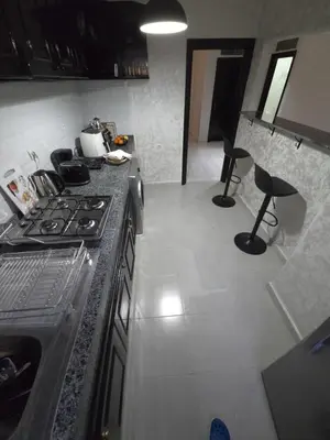 a kitchen with a stove and two chairs in it at Havre de paix en plein coeur de Casa in Casablanca