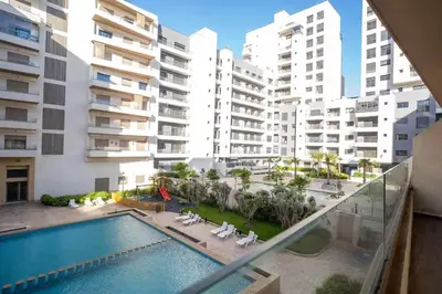 an apartment with a swimming pool and some buildings at Charming Studio for Rent with Pool Access & Kids Playground in Casablanca