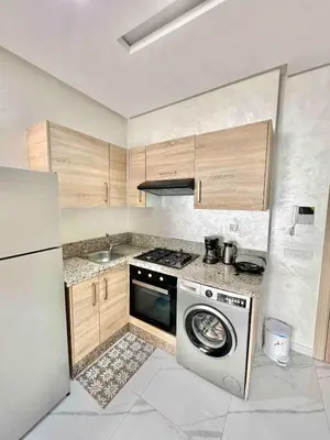 a kitchen with a stove and a washing machine at Charming Studio for Rent with Pool Access & Kids Playground in Casablanca