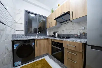 a kitchen with a sink and a dishwasher at Appartement 2 Chambres à Coté avec Grand Balcon, Piscine, Aire de Jeux pour Enfants et Jardin in Casablanca