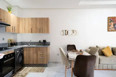 a kitchen with a table and a couch at Studio Confortable avec Balcon, Piscine, Jardin et Aire de Jeux in Casablanca