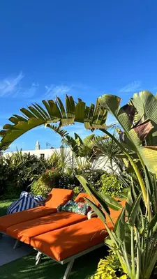 two orange beds sitting on the grass with plants at HBkf Residence in Casablanca