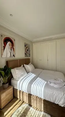 a bedroom with a large bed with a painting on the wall at HBkf Residence in Casablanca