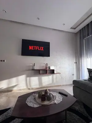 a living room with a table and a sign on the wall at Nova Casa in Casablanca