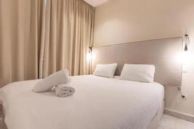 a hotel room with a bed with a stuffed animal on it at Cosy Studio - Fitness access & Free Parking & Wifi Fiber in Casablanca