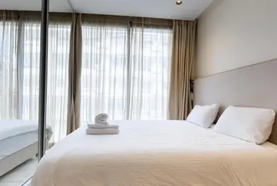 a bedroom with a large white bed and large windows at Cosy Studio - Fitness access & Free Parking & Wifi Fiber in Casablanca