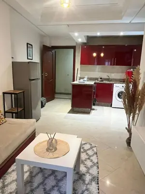a living room with a white table and a kitchen at La Parenthèse de CASABLANCA in Casablanca