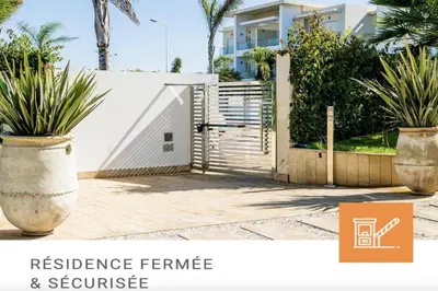 a gate to a house with two potted plants at Welcome Sidi Rehal Escape King Bed Res Casabay in Sidi Rahal
