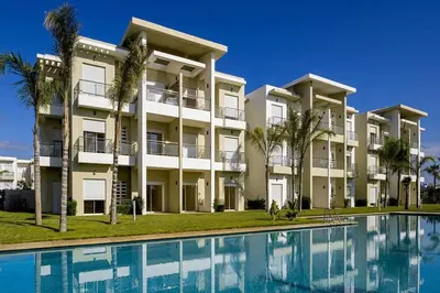 an apartment building with a swimming pool in front of it at Welcome Sidi Rehal Escape King Bed Res Casabay in Sidi Rahal