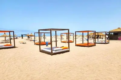 a row of beds on a sandy beach at Welcome Sidi Rehal Escape King Bed Res Casabay in Sidi Rahal