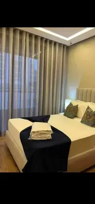 a bedroom with two beds and a window with curtains at LA Princesse 12th in Casablanca