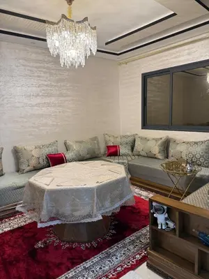 a living room with a couch and a chandelier at Comfortable and quiet apartment with Buzzinga in Bouznika
