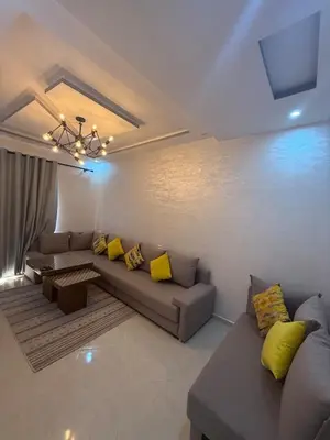 a living room with a couch and yellow pillows at Comfortable and quiet apartment with Buzzinga in Bouznika